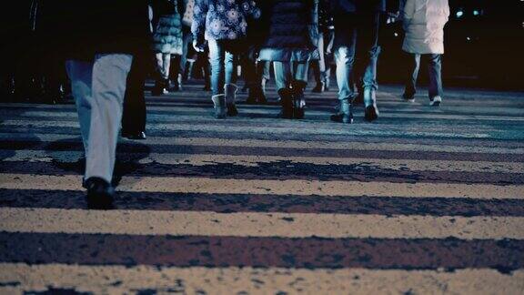 一群人走在人行横道上夜晚的城市大都市商人们穿梭在马路上交通安全车速前照灯