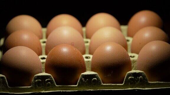 在黑色背景下旋转的盒子里的棕色鸡蛋