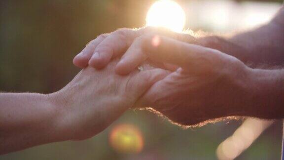 一对深情的老夫妇在日落时牵着手