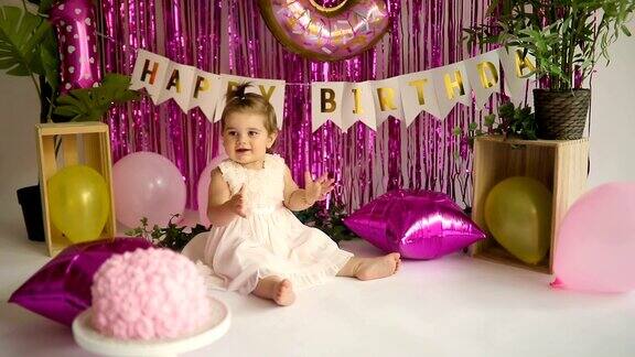 微笑的小女孩在她的生日蛋糕前拍手