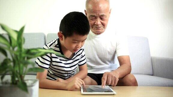 祖父和孙子使用数字平板电脑