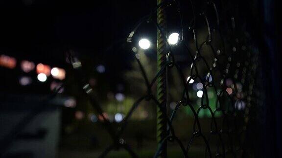 金属网空旷的篮球场在夜晚的灯光下监狱的围墙