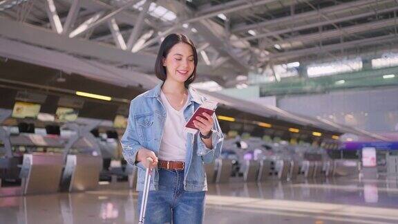 年轻漂亮的女士乘客拿着机票和护照走在机场航站楼到登机口那个女孩开心地笑着去国外旅行航空公司经营理念