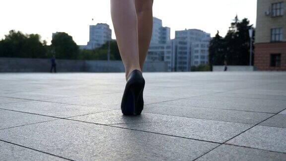 女人们穿着高跟鞋走在城市的街道上穿着高跟鞋的年轻女商人的脚在城市中穿行一个面目全非的女孩走上工作岗位慢动作特写后视图