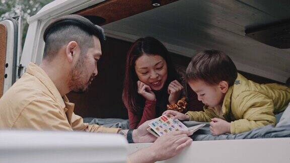 亚洲家庭在小货车上读儿童读物