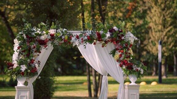 特写婚礼拱门与圆柱装饰着花瓶的花朵白布