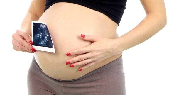一名孕妇拿着她宝宝的超声波扫描图白色特写