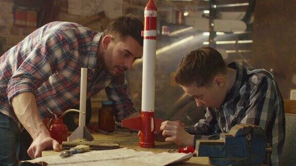 父亲和儿子正在家里的车库里制作玩具火箭
