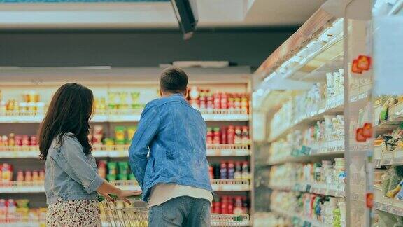 购买者在商店的橱窗里挑选乳制品去超市购物