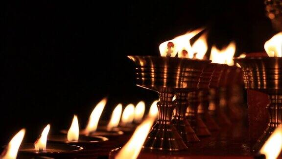 寺庙牛油灯节上的佛坛蜡烛视频在金属容器中祈祷的油灯和摇曳的火焰宁静的风景