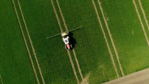 植物保护拖拉机在给绿色麦田喷洒农药鸟瞰图