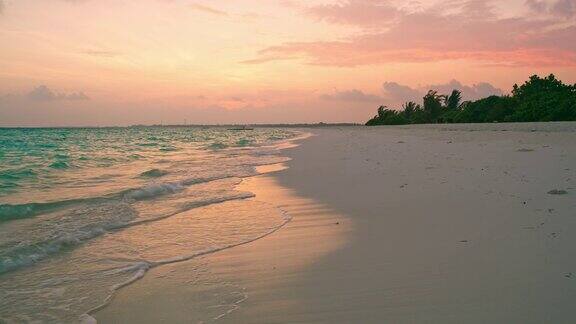 宁静的田诗式的轻拍海洋在宁静的热带海滩上的日落马尔代夫