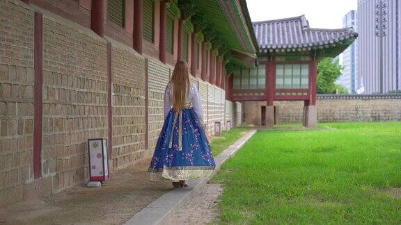 穿着韩国传统服饰韩服的年轻女子参观韩国首尔的古代宫殿去韩国旅游Slowmotion拍摄