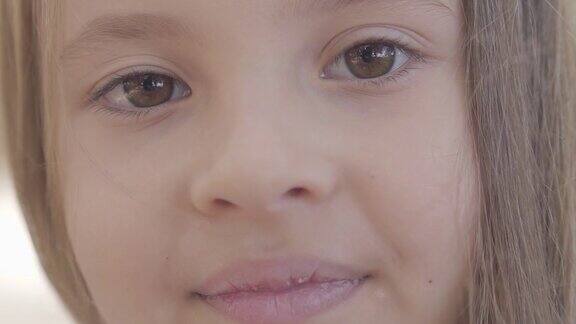 一个年轻美丽的棕色眼睛的女孩的特写黑发微笑的镜头