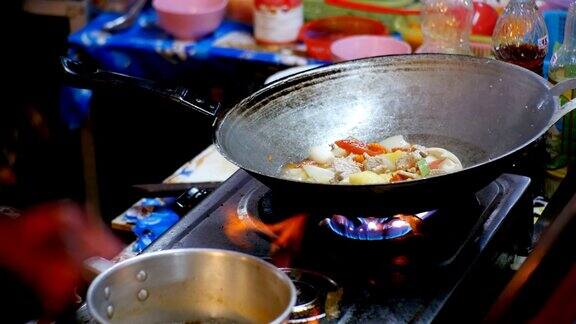 在宗田夜市用煎锅准备亚洲食物的女小贩泰国芭堤雅