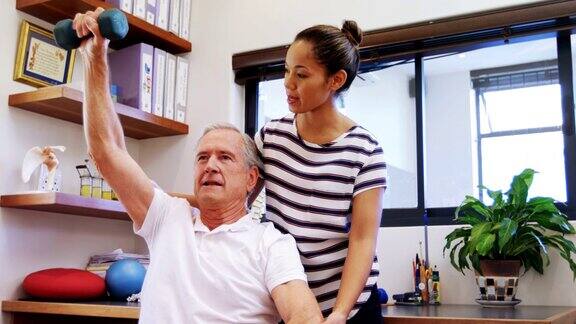 物理治疗师帮助病人用4k哑铃进行运动