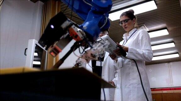 在实验室里使用机械臂工作的女性工程师