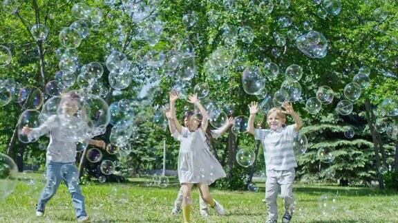 可爱的孩子在公园里爆裂巨大的泡泡