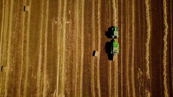 4k现代拖拉机在收获后在田里堆干草堆空中俯视图