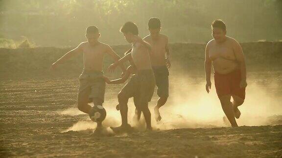 乡村的孩子们在阳光明媚的日子里踢足球
