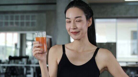 亚洲美女在健身房喝果汁的肖像