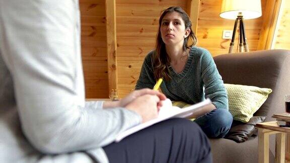 一位戴着人工耳蜗的年轻女子正在与一位心理学家交谈
