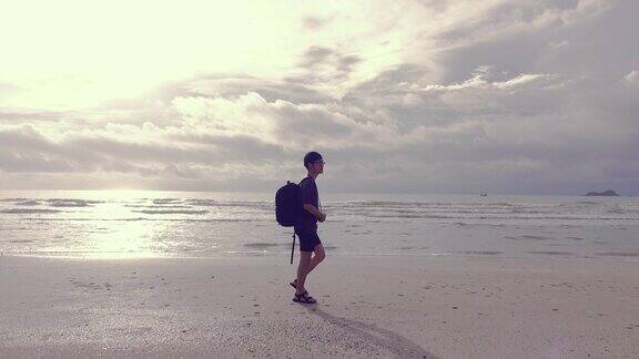 日出时分一名男子沿着海边散步