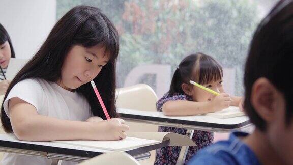 女孩在课堂上专心听老师讲课和写作教育