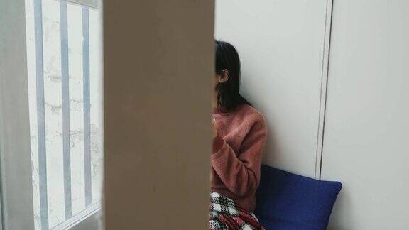 女孩享受在家里的咖啡靠近窗户