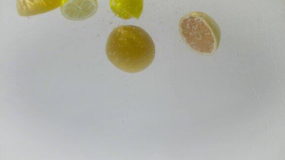 切片的葡萄柚和柠檬落入水中超慢动作