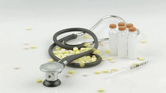 慢动作中药片掉落在听诊器、注射器和小瓶上