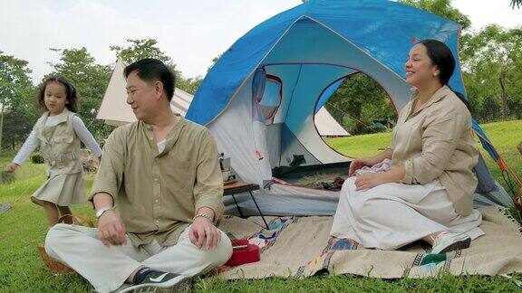 亚洲家庭一起享受露营度假湖边
