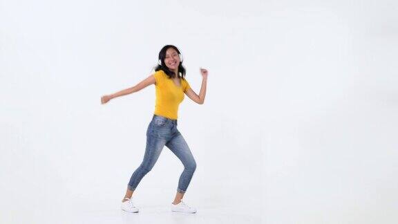 亚洲年轻女子一边戴着耳机听音乐一边跳舞