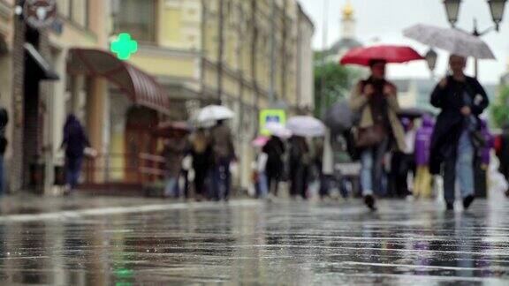 城市街道上的雨天背景真正的时间人们在雨中带着雨伞上下班模糊的散景自然背景