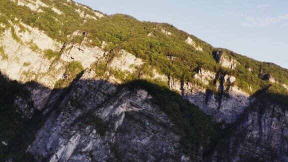 在旭日的映照下长满茂密森林的石质山坡