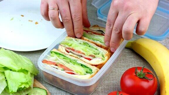 女人做了三明治把它们放进午餐盒里