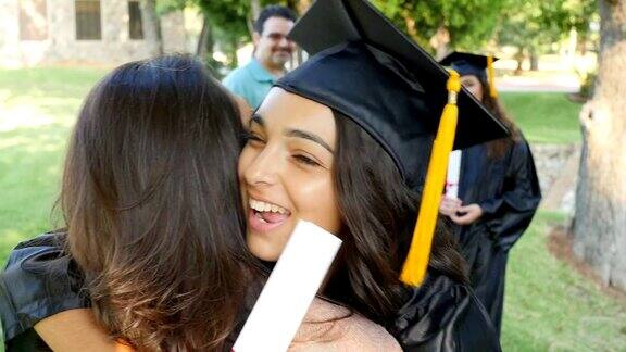 刚毕业的大学生在毕业典礼后兴奋地拥抱妈妈