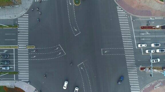 无人机拍摄的城市十字路口汽车和公交车行驶在大道上在日落时