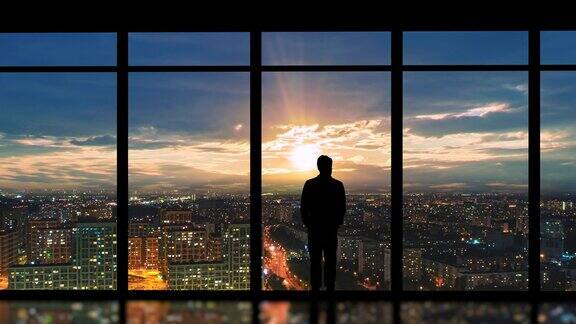商务人士站在落地窗前欣赏城市风光