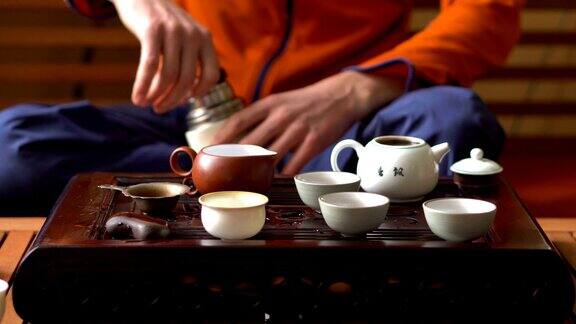 在中国传统茶道上一名男子将开水倒进茶壶一套饮茶设备