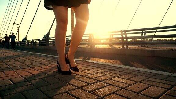 女商人穿着高跟鞋走在阳光下