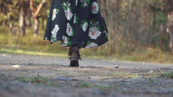 女人穿着带花的长裙走在地上的路上女孩走在户外