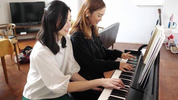 女性朋友一起弹钢琴