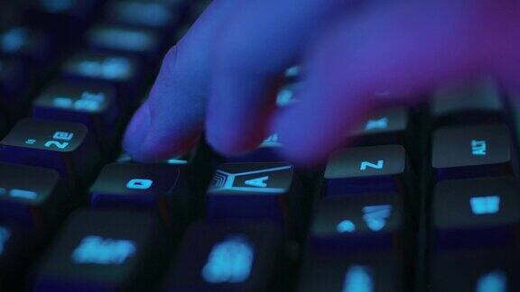 特写在时尚的霓虹灯键盘上按按钮的手指