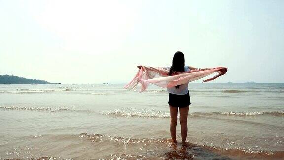 在海滩上围着围巾的女人