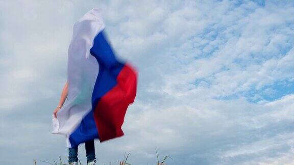 4k金发女孩在夏天的蓝天上挥舞着俄罗斯国旗俄罗斯国旗国家爱国主义俄罗斯日6月12日