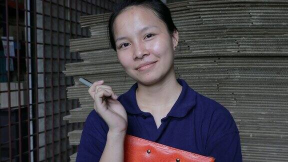 亚洲女性仓库主管对着镜头微笑