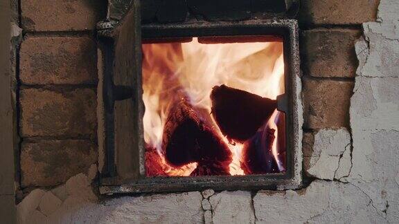 壁炉古老的俄罗斯烤箱用燃烧的木头火在敞开的门