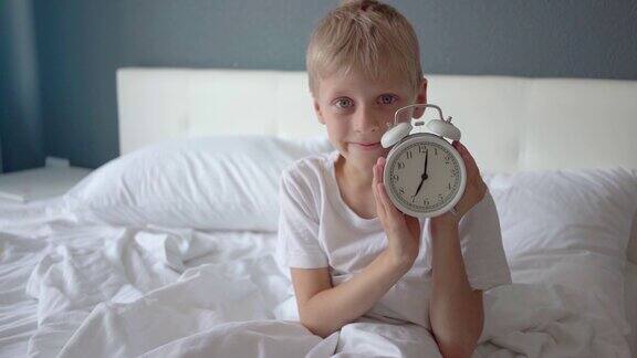 可爱快乐的男孩早上醒来闹钟该起床了该走了