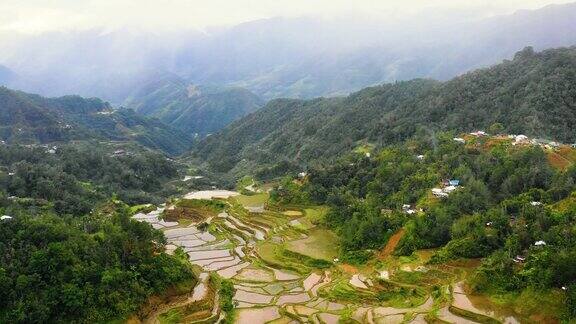 一架无人机俯瞰菲律宾梯田中间房屋的全景在被群山包围的山谷里绝妙的农业-4K